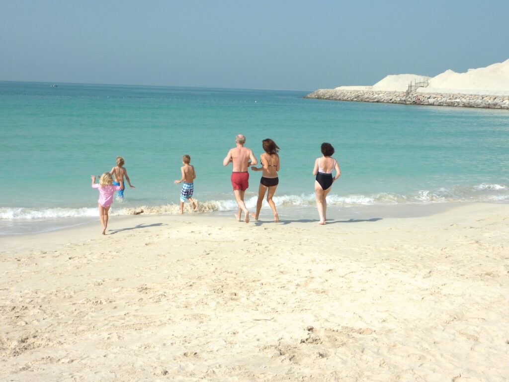 Family running into the sea on a deserted beach