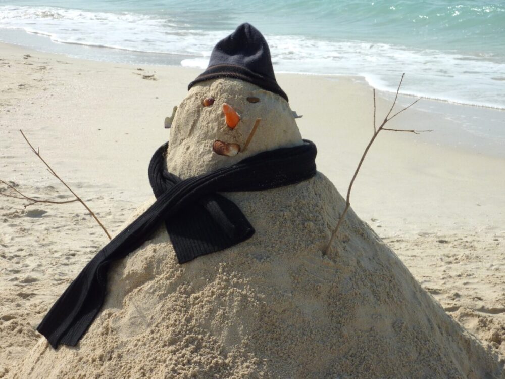 Snowman made out of sand on a beach