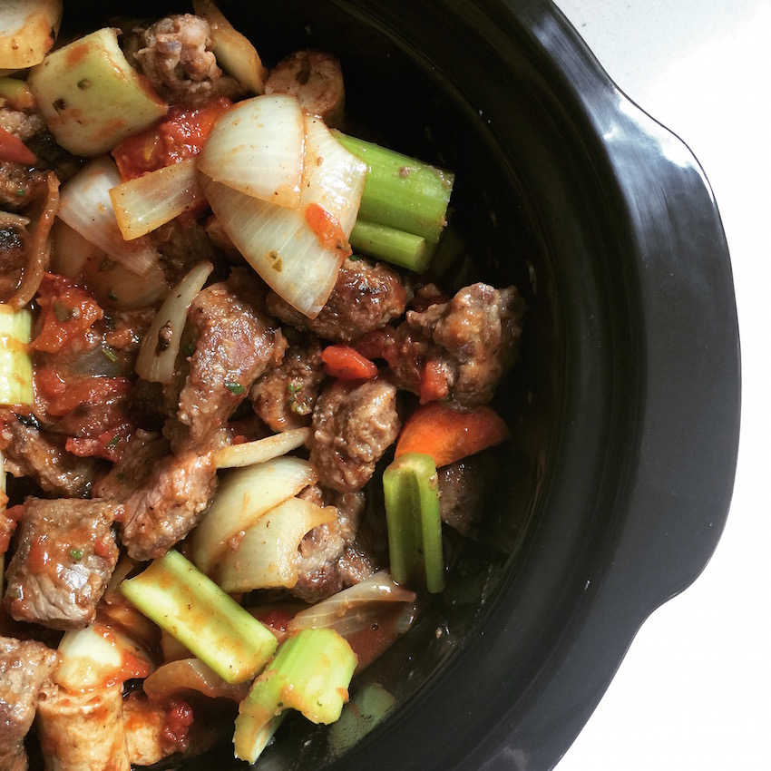 Ingredients for slow cooker beef and sausage casserole in the pan