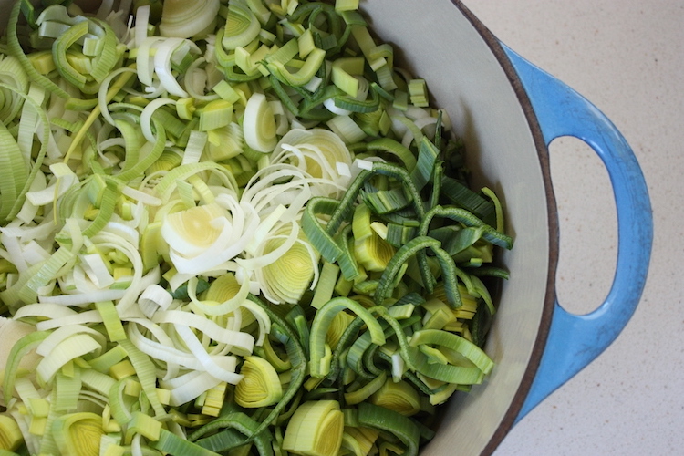 Sliced leeks for Chickpea and Leek Soup in a blue pan