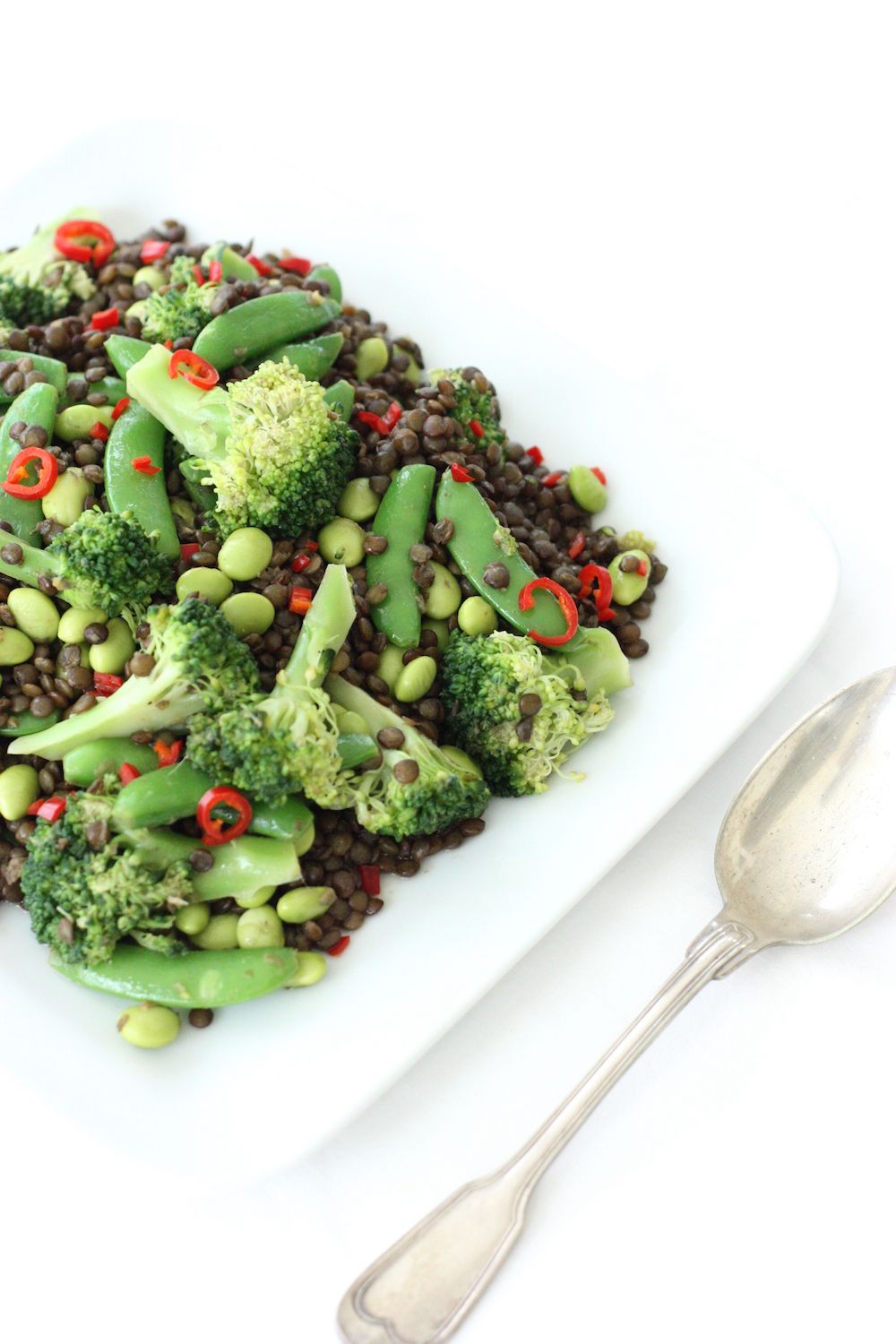 Puy Lentil Salad on a square white dish with a serving spoon