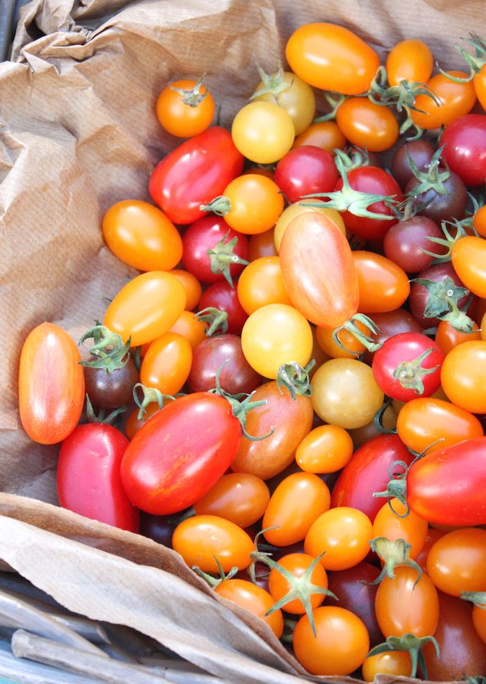 Multi-coloured cherry tomatoes on brown paper
