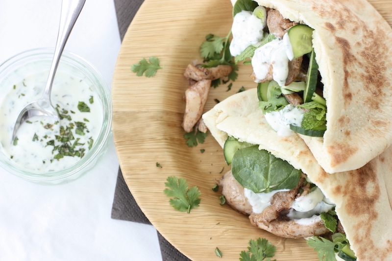 Baharat Chicken Flatbreads on a bamboo plate with a yoghurt dressing on the side