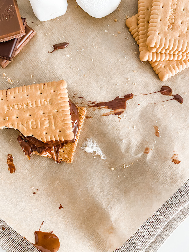 A half eaten Everyday Oven S'mores on brown paper shot from above