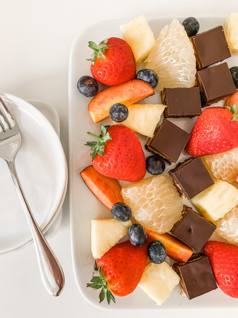 Chocolate tiffin on a white plate with fruits