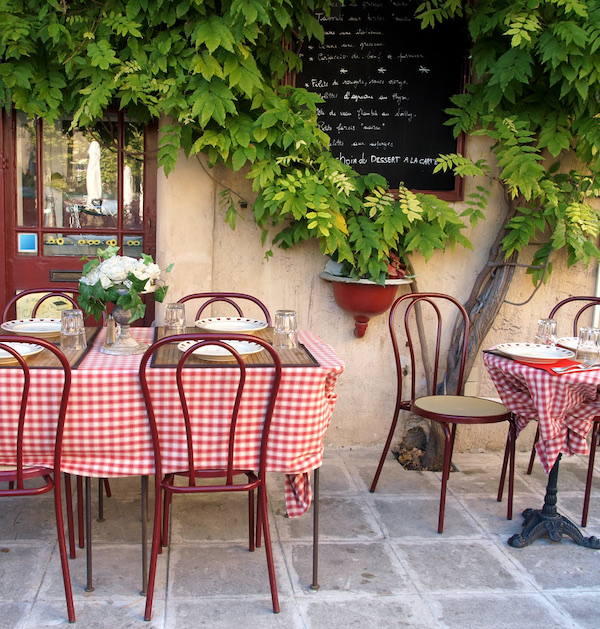 A french pavement cafe with red and white checked tablecloths