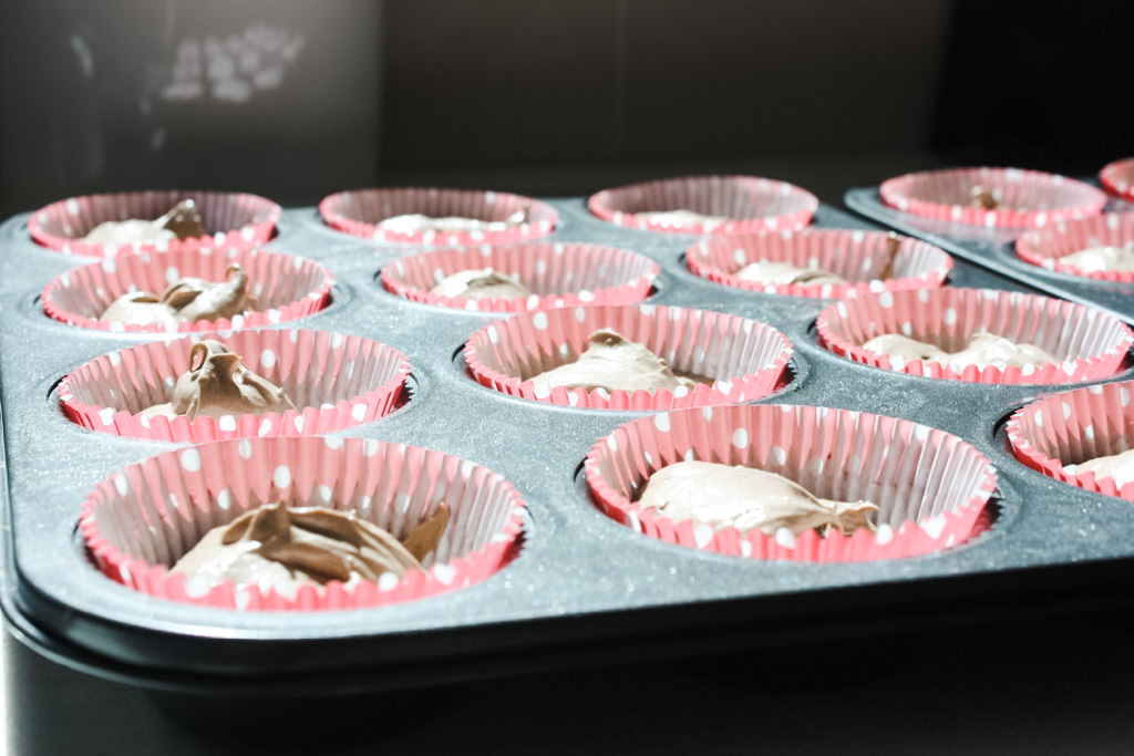 Cake mixture in the tins for chocolate cupcakes