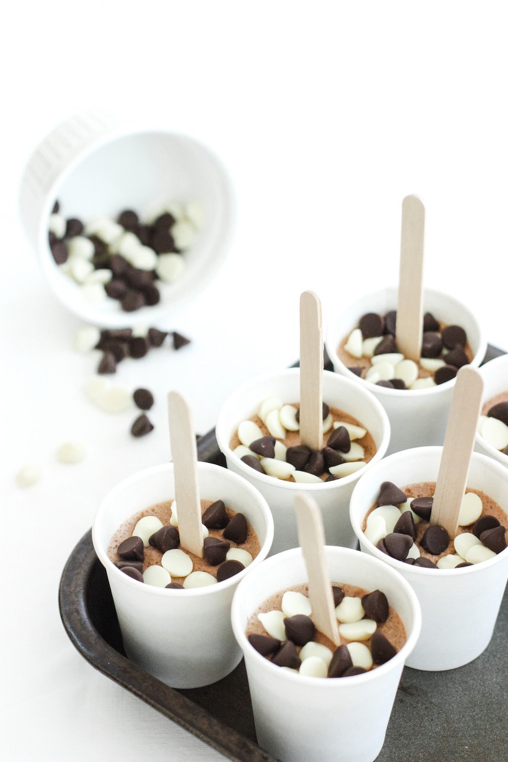 Chocolate Fudge Popsicles in a tray with chocolate chips sprinkled on top