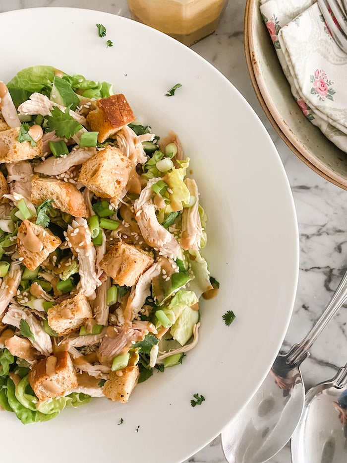 Delightful Summer Chicken Salad in white dish with serving cutlery
