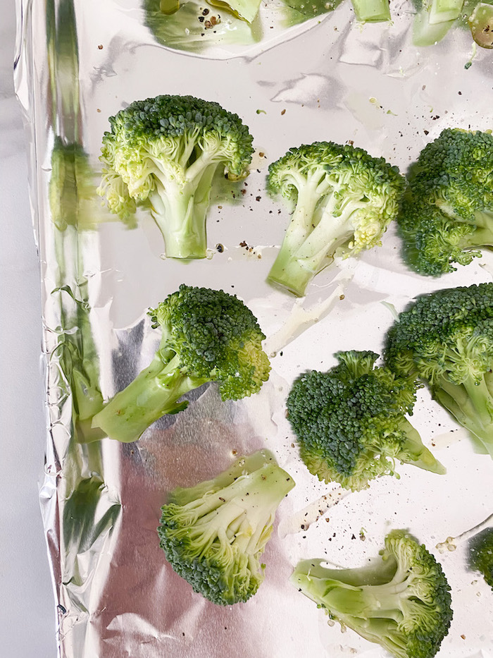 Roasting broccoli on a tray for Vegan Green Veggie Bowls