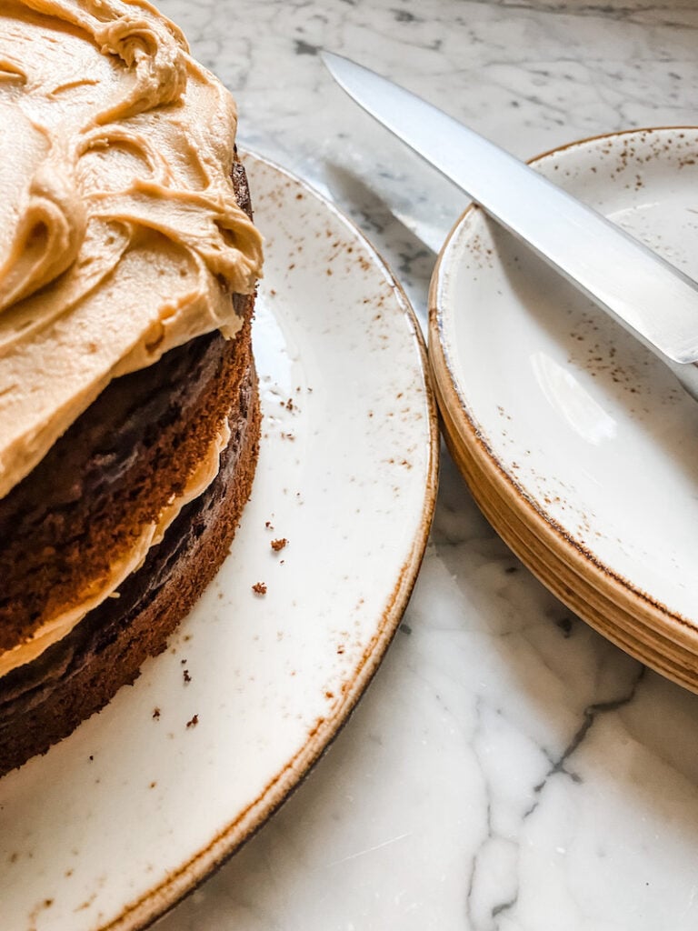 Coffee and Chocolate Layer Cake, the full cake with a pile of side plates and a sharp knife