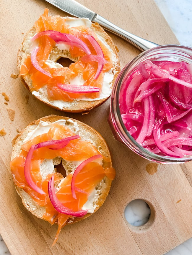 A salmon and cream cheese bagel with pickled red onions