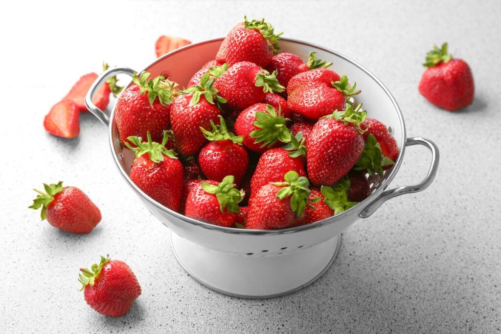 Strawberries in a white colander