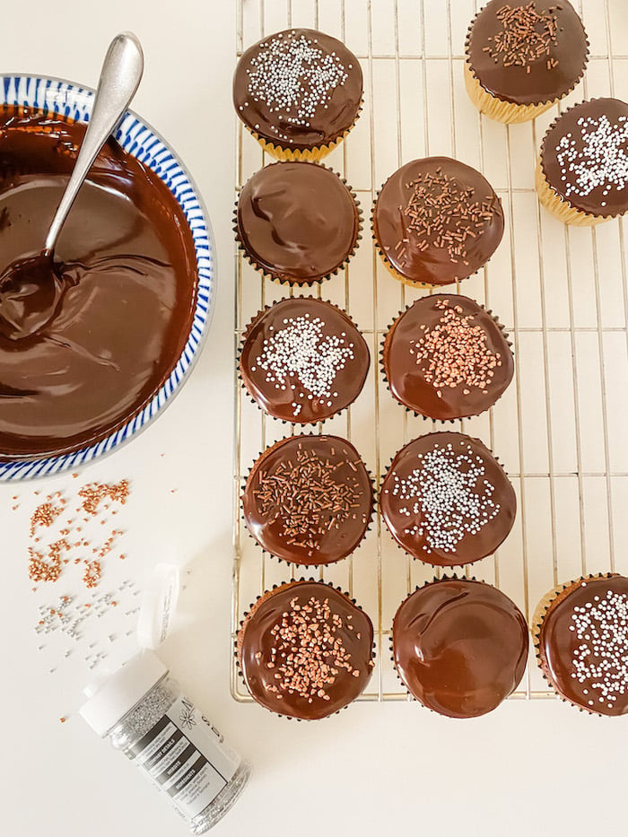 Chocolate Ganache being used to top cupcakes