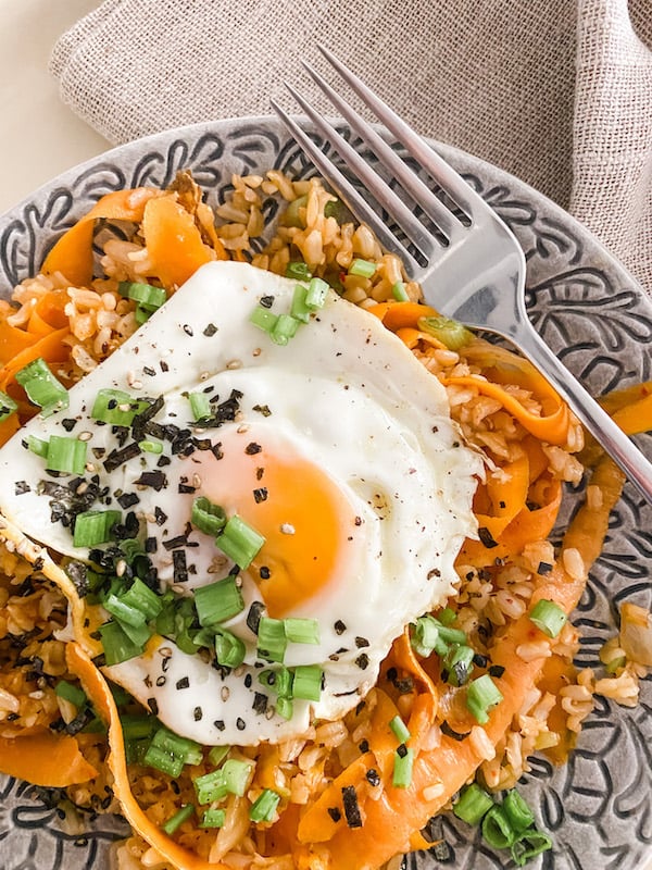 Kimchi Fried Egg Rice served on a grey plate with a fork