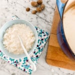 Rice Pudding in a small blue bowl next to a wooden board