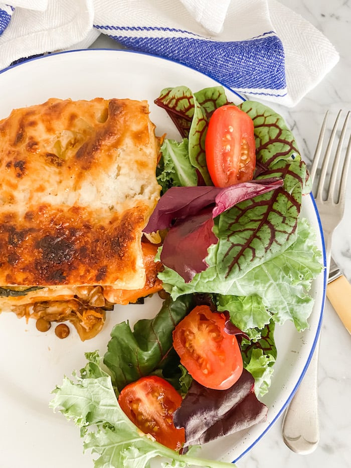 Roasted Vegetable and Lentil Lasagne with salad on a white plate