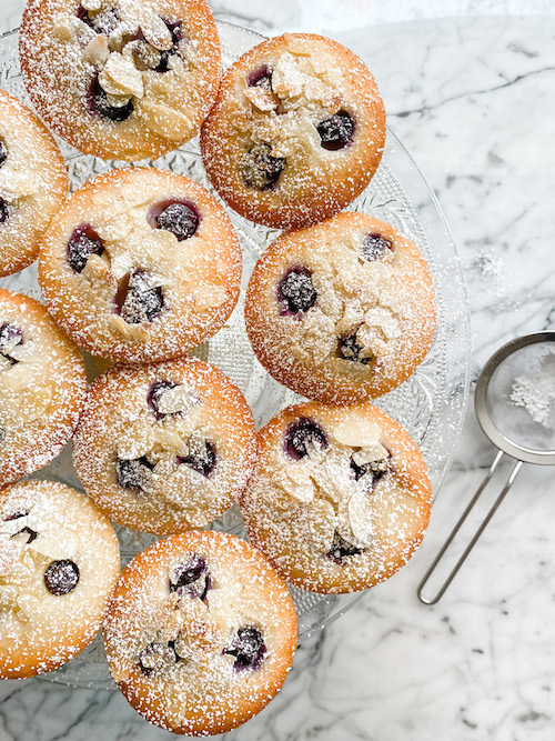 Blueberry and Lemon Friands on a glass cake stand