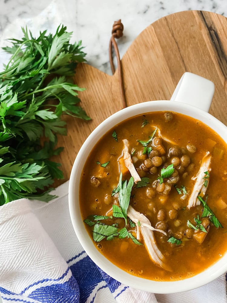 Cosy Chicken and Puy Lentil Soup on wooden board