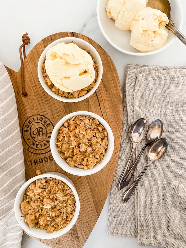 Individual Apple Crumbles on wooden board with ice cream
