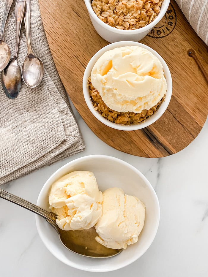 Individual Apple Crumbles on wooden board with ice cream